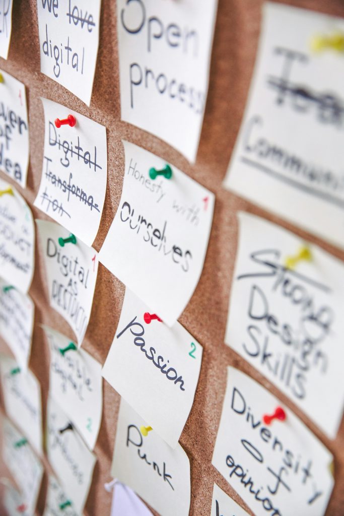 Corkboard with handwritten colorful sticky notes showing creativity and planning concepts.